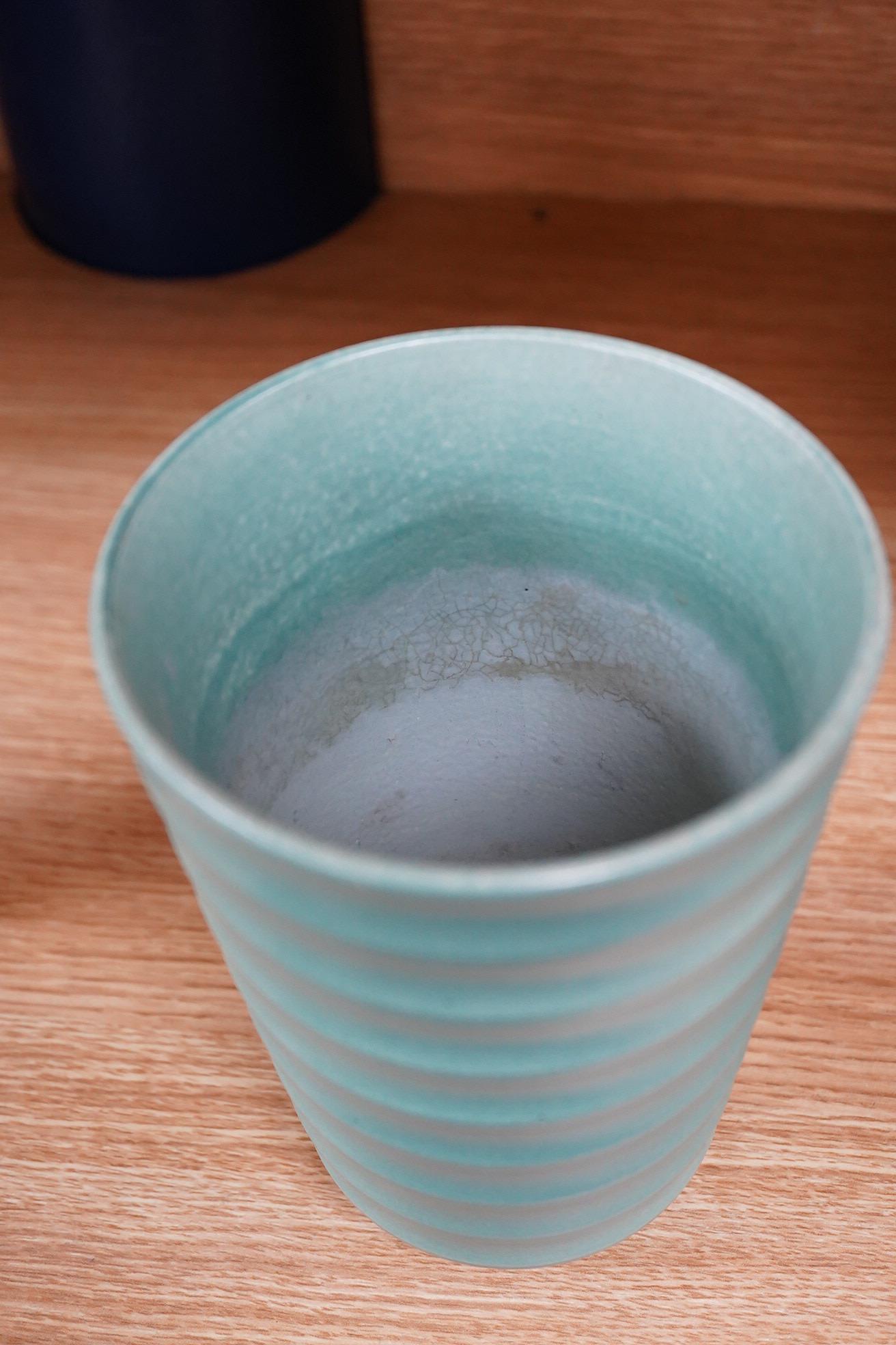 Keith Murray for Wedgwood, a ribbed tapering green glazed vase, 18cm high